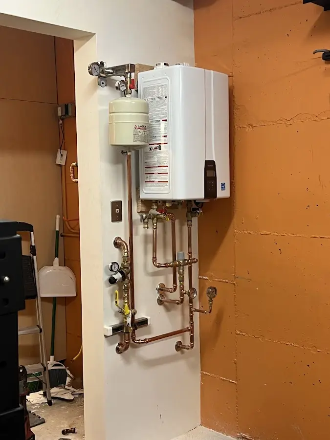 Plumbing technician inspecting water heater connections in Lindenwold